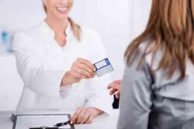 Patientin und Arzthelferin mit Versicherungskarte 